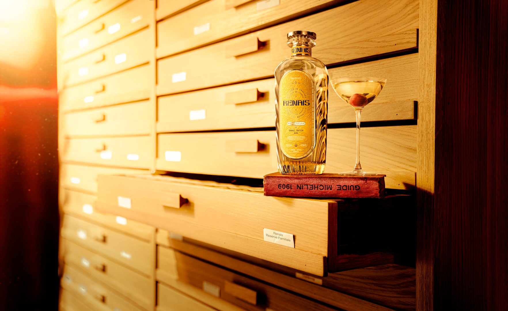 Renais bottle beside a finished martini